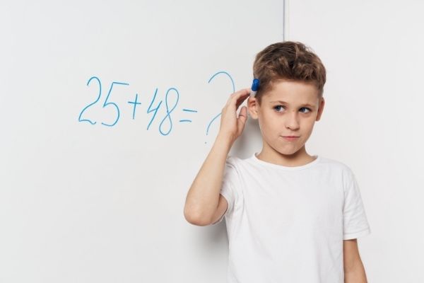 Little boy thinking how to regroup numbers using split subtraction